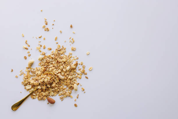 istock Granola on spoon isolated on white background, copy space. Healthy snack or breakfast concept - homemade granola with grains and nuts 1478198458