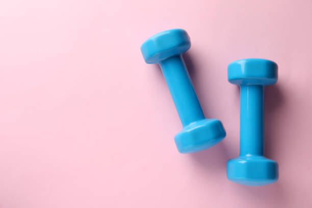 istock Turquoise dumbbells on pink background, flat lay. Space for text 1478200126