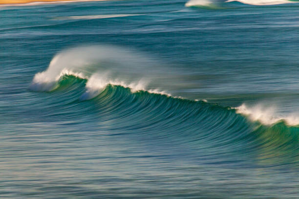 istock Blurred motion of a wave breaking on the beach with offshore winds 1478205268