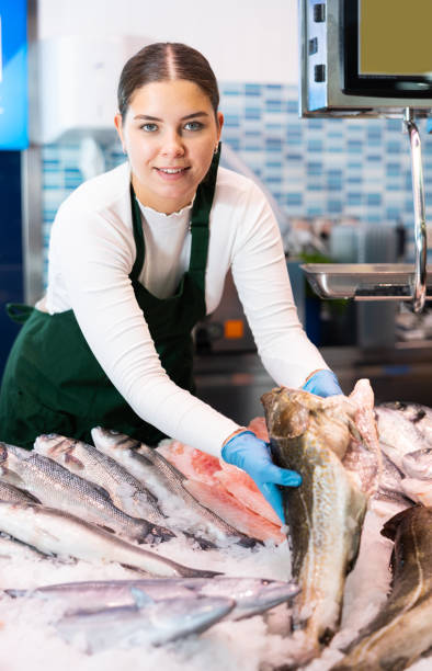 istock Saleswoman offering fresh fish atlantic cod at seafood shop 1478206123