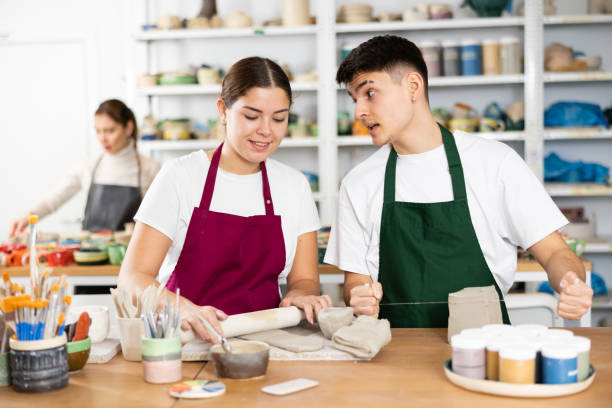 istock Joyous young man and woman sculpting handmade cups 1478207131