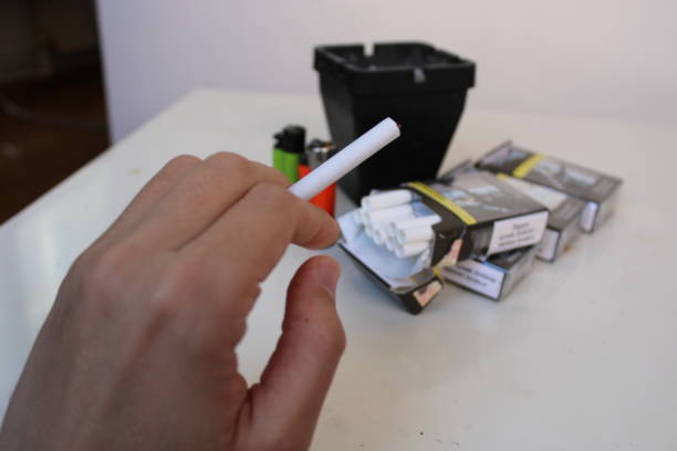 istock A hand holds a cigarette in a black box with a green label that says'smoke'on it. 1478207581