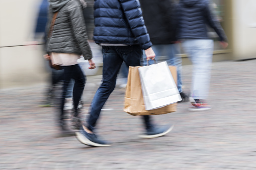 picture with motion blur of a shopping couple walking in a pedestrian area of a city