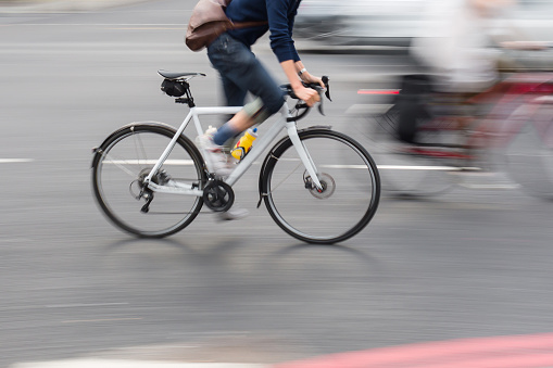 picture with intentional motion blur effect of a man on a racing bike in the city traffic