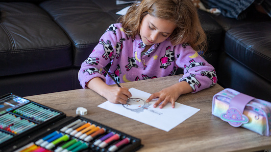 beautiful girl between 7 and 10 years old drawing at home