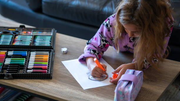 belle fille entre sept et dix ans dessinant à la maison un beau dimanche matin - 6 7 years photos et images de collection