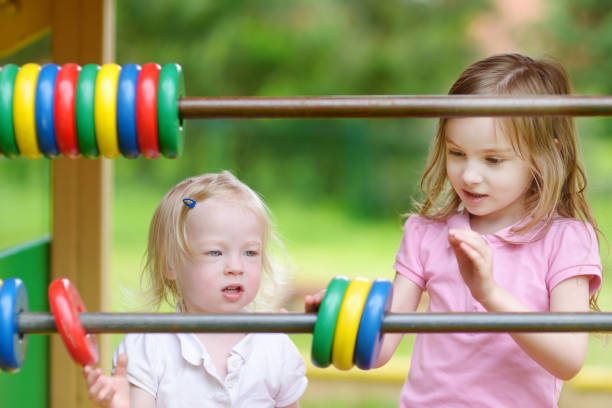istock Two little sisters learning to count using giant abacus in a playground 1478223514