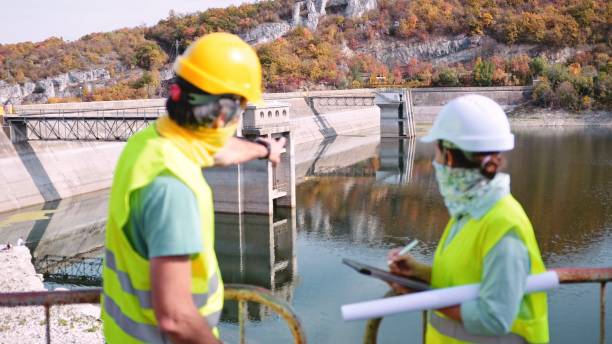 istock Engineers work at hydroelectric power plant with protrctive face masks. 1478226155