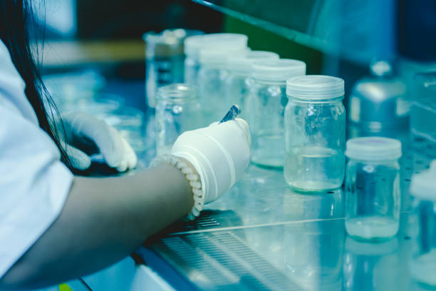 The scientist's hands pouring solvent into the bottles