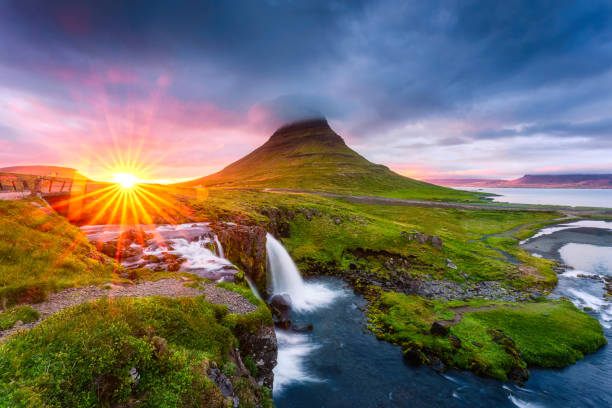 sonnenuntergangslandschaft über dem berg kirkjufell mit wasserfall und pileuswolke im sommer in island - waterfall iceland landscape stream stock-fotos und bilder