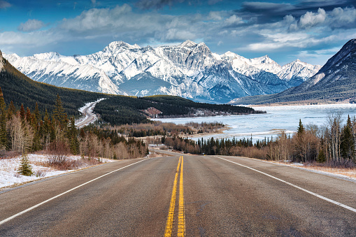 Beautiful scenery of Road trip on highway with rocky mountains and frozen lake at Icefields Parkway, Alberta, Canada