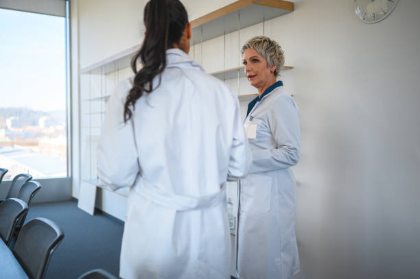 istock Busy Female Doctors Talking and Walking to Board Room 1478243696