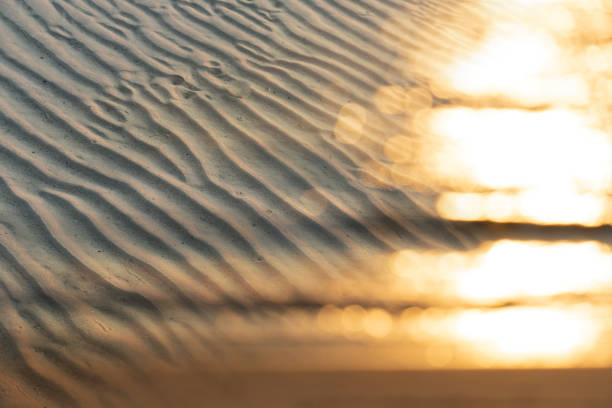 ripple sand beach at the sea with sunlight bokeh
