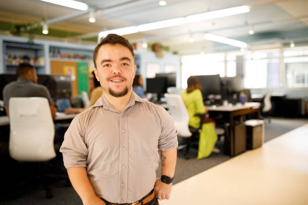 Happy man in the office smiling to the camera Office meetings short stature stock pictures, royalty-free photos & images