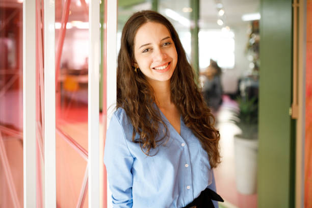 istock Long haired office lady smiling while leaning on the door 1478252279