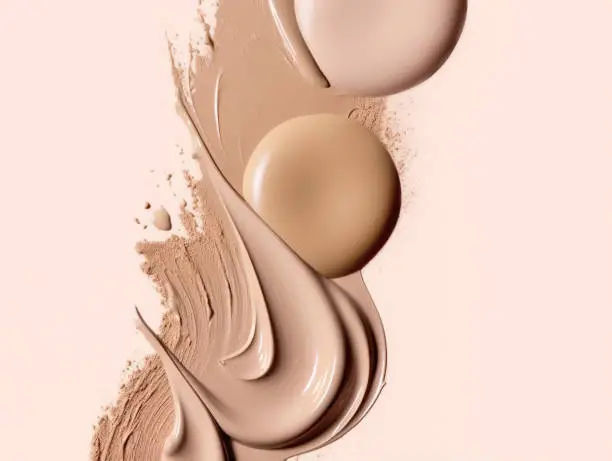 Composition with cosmetics swatch foundation on a pastel beige background. Cosmetics swatch with makeup concealers, cream, Foundation. Top view