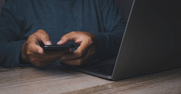 istock Businessman using smartphone with laptop. 1478271493