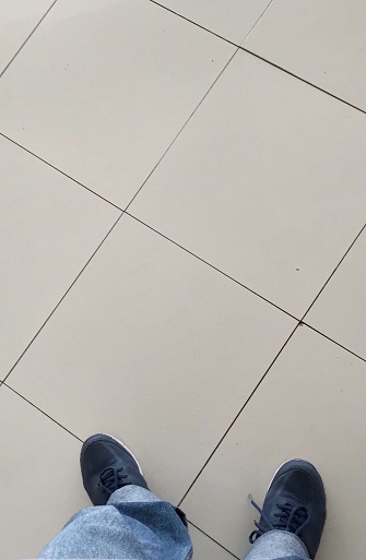 feet wearing shoes and standing on a white floor