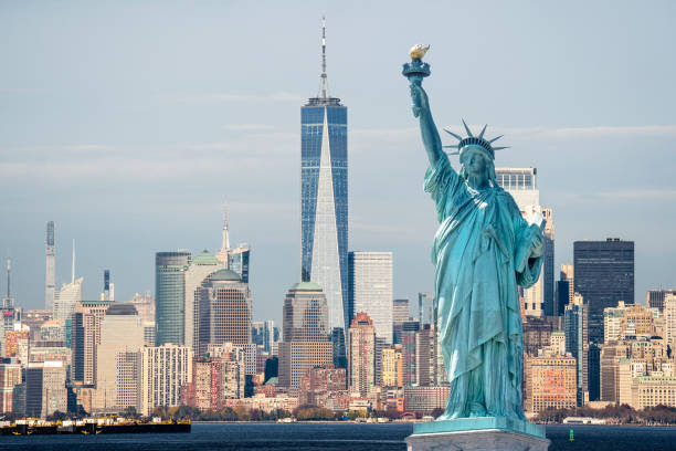 estatua de la libertad en el fondo de manhattan durante un buen día. estatua de la libertad frente a la ciudad de nueva york - statue of liberty fotos fotografías e imágenes de stock