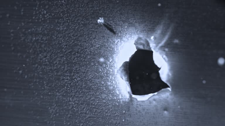 SLO MO LD Bullet making a hole through a thin metal sheet