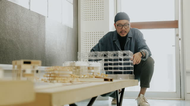Master degree student present's the architectural models to professor with passion