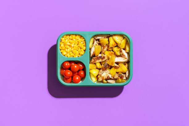 도시락 상자에 여름 샐러드, 보라색 배경에 상위 뷰. 실리콘 용기에 열대 요리입니다. - lavender orange fruit table 뉴스 사진 이미지
