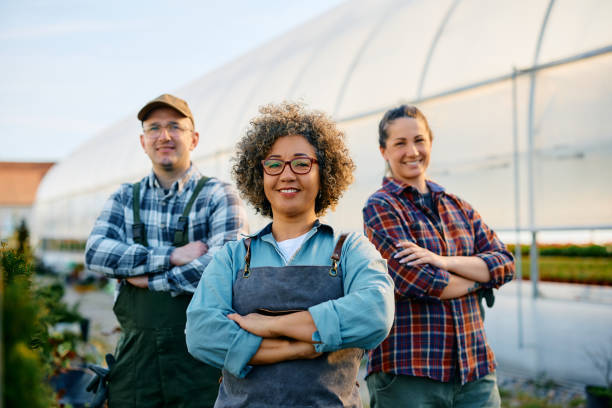 istock Confident greenhouse owner and her workers looking at camera. 1478288888