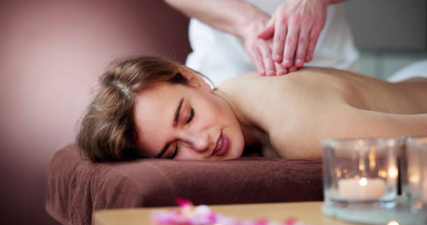 schöne junge frau, die massage bekommt zurück - massage table massaging sport spa treatment stock-fotos und bilder