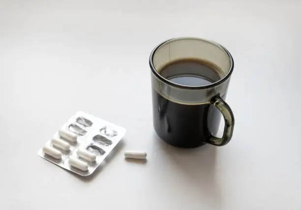 Coffee Mug with a Pills on the White Table closeup