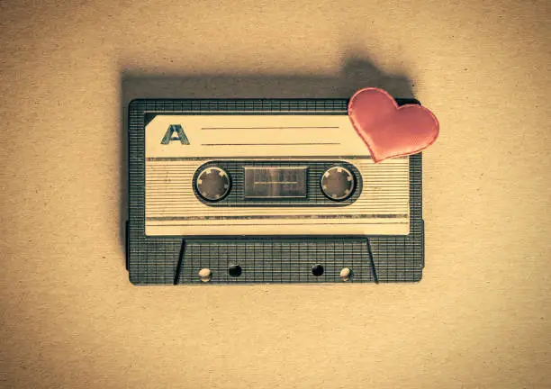 Toned Photo of the Old Audio Tape Cassette with a Red Heart on the Paper closeup