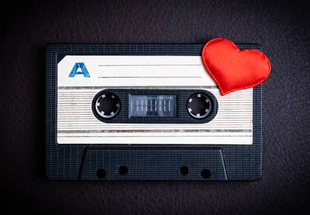Audio Tape Cassette with a Red Heart on the Dark Background closeup