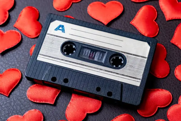 Old Audio Tape Cassette on a Scattered Red Hearts closeup