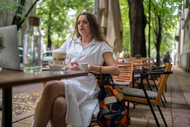 istock Businesswoman using laptop while enjoying work at cafe table with cup of coffee 1478290764