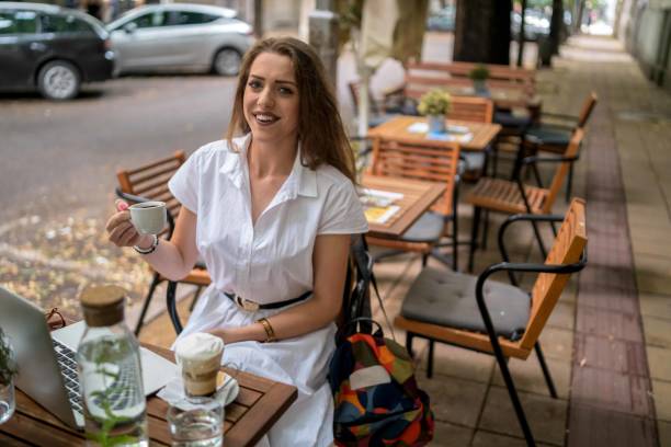 istock Businesswoman using laptop while enjoying work at cafe table with cup of coffee 1478290824