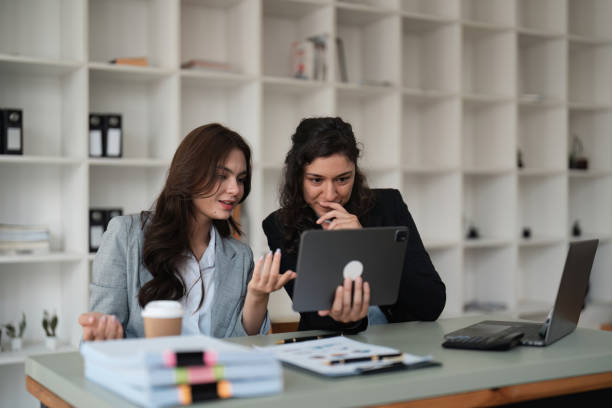 istock Two smart multiethnic business people working together with laptop while working on project in office 1478294504