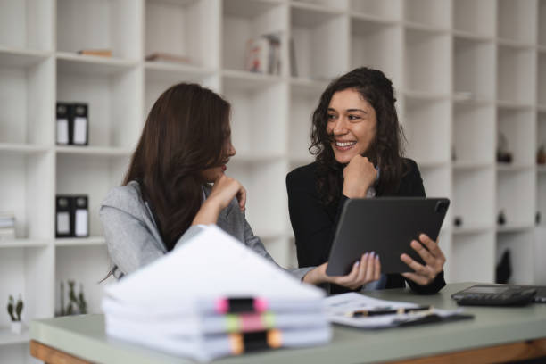 istock Two smart multiethnic business people working together with laptop while working on project in office 1478294519