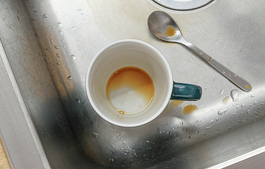 Dirty coffee dishes in the sink of the office kitchen. Again someone was too lazy to put the used dishes into the dishwasher.