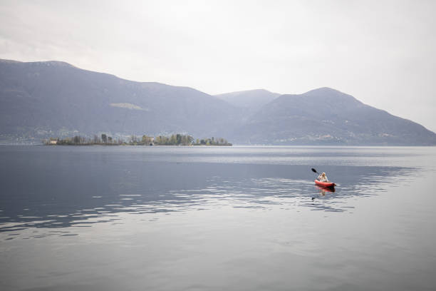 istock Distant person canoeing on calm lake on an overcast day 1478296081