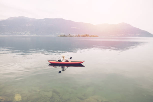 istock Woman canoeing on calm lake 1478296162