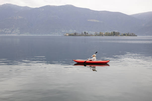 istock Woman canoeing on calm lake 1478296202