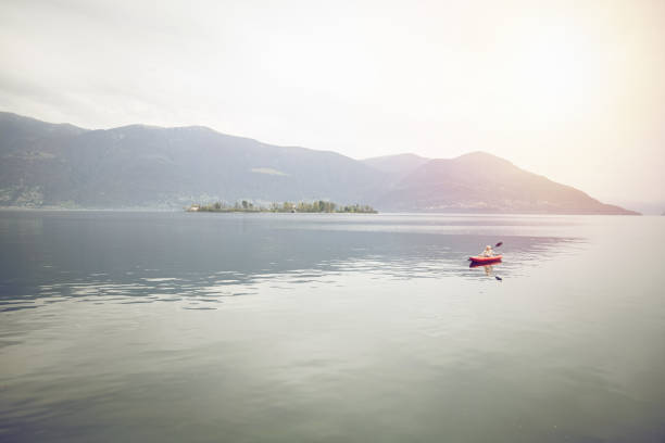 istock Distant person canoeing on calm lake on an overcast day 1478296774