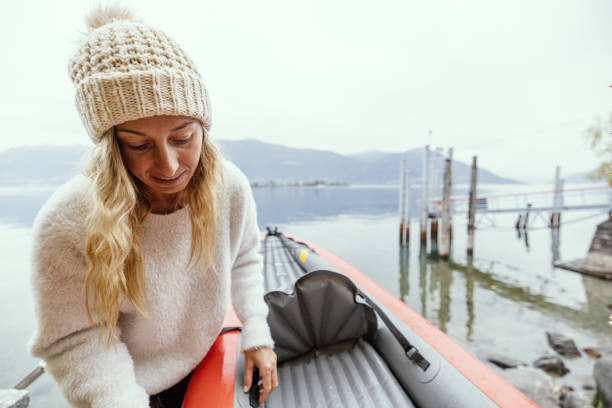 Woman preparing canoe, adjusting the seat post