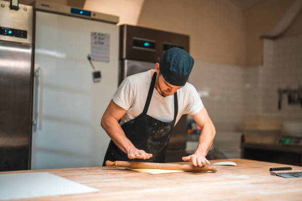 istock Artisan Baker Rolling Wrapped Butter At Bakery 1478300462