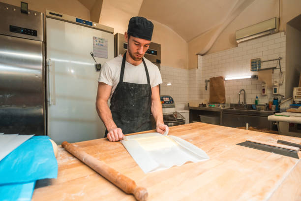 istock Caucasian Artisan Baker Rolling Butter Wrapped In A Baking Paper 1478300486