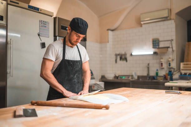 istock Caucasian Baker Wrapping Butter In A Baking Paper 1478300511