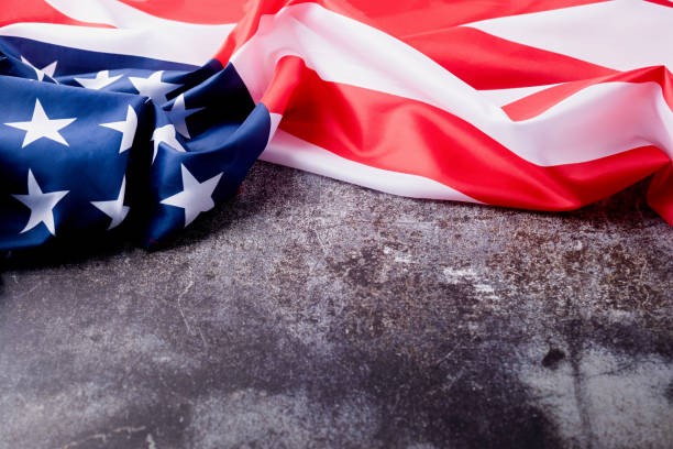 istock Closeup of American flag on dark cement background 1478303549