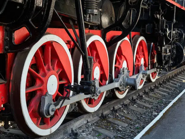 Photo of large metal wheels of an old train at a railway transport exhibition
