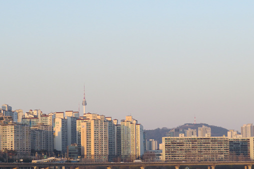 Reflection of sunset light on a building in South Korea. From a distance, you can see the top of Namsan Tower with evening atmosphere
