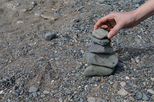 Detail of person stacking rocks.People life balance concept