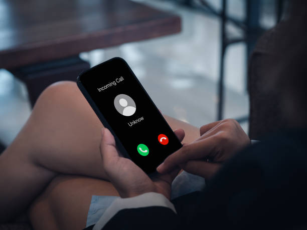 istock Incoming call with unknown caller, malicious phone calls concept. Unknown number displayed showing on smart mobile phone in business person hand. Spam and robocalls, scam call alert. 1478307383